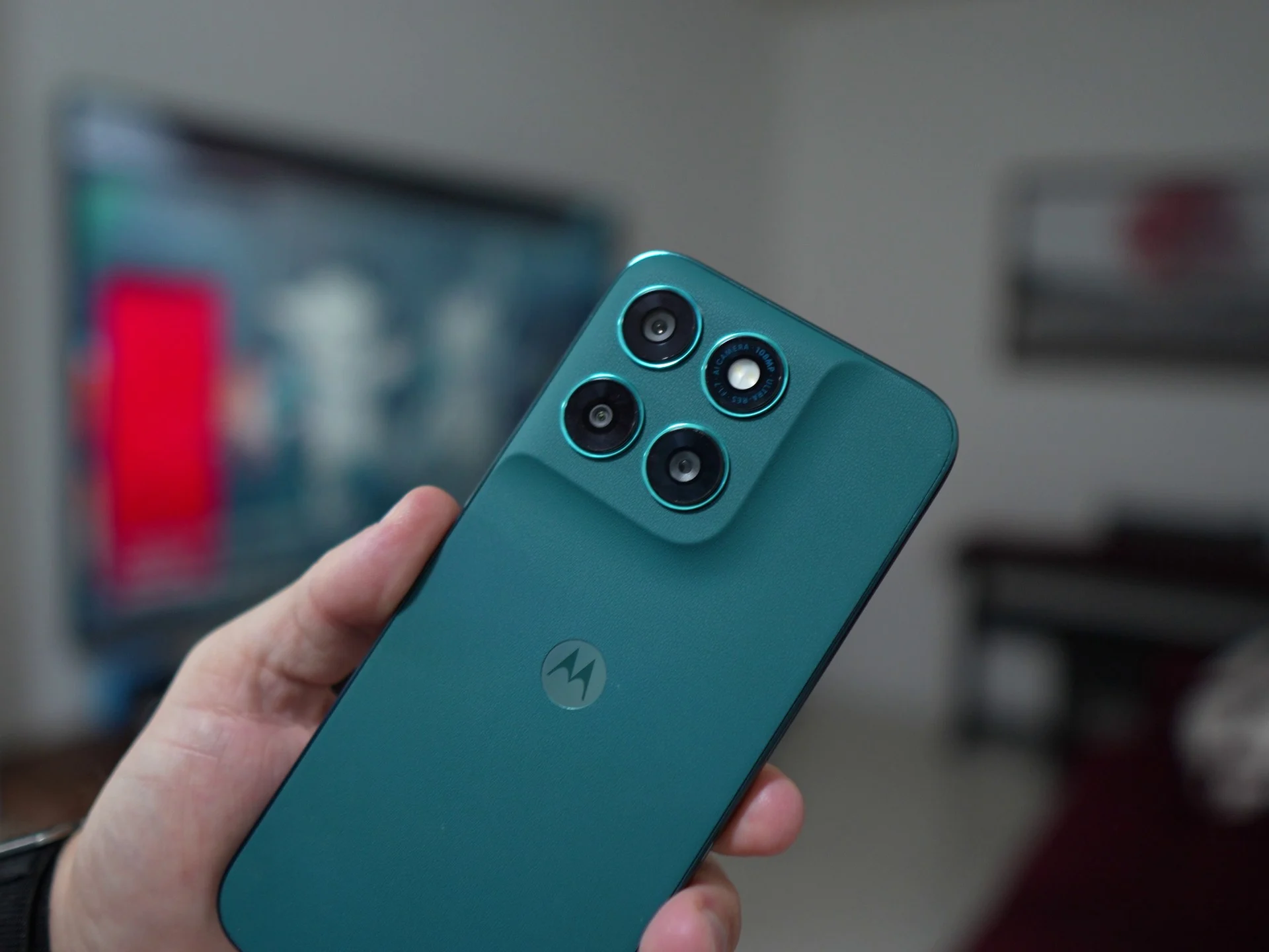 Mão segurando o Moto G77 5G na cor verde-azulado, com módulo de câmera tripla em destaque