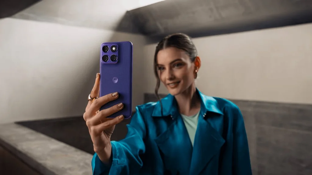 Uma mulher sorridente tirando uma selfie com a câmera de 32 MP do Motorola Edge 70 Fusion na cor roxa